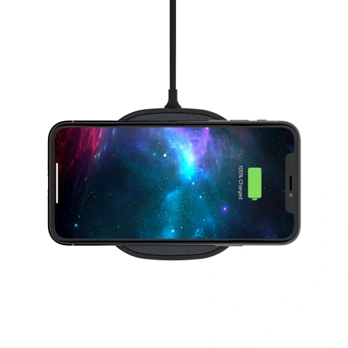 Mophie Wireless Charging Pad Fast Charge 15W in Aktion, lädt ein Smartphone kabellos.