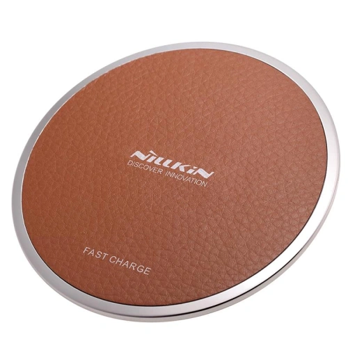 Nillkin Magic Disk III wireless charger in brown on a wooden table.