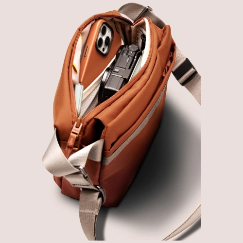 Torba Crossbody UNIQ Denver 5L w pomarańczowym, prezentująca nowoczesny design.